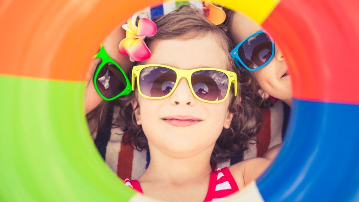 Travelling abroad - picture of a little girl with sunglasses seen through a rubberring